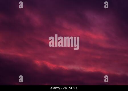 Full frame view heavy moody sky cloudscape bright pink violet colors Stock Photo