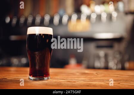 Glass with cold unfiltered beer on background of bar Stock Photo