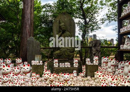 Thousands of maneki-neko statues displayed in the garden of Gotokuji Temple in Tokyo, Japan Stock Photo