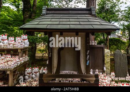 Thousands of maneki-neko statues displayed in the garden of Gotokuji Temple in Tokyo, Japan Stock Photo