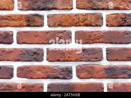 Decorative brick wall from of brown bricks. Background and texture of brickwork. Stock Photo