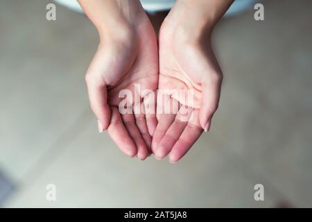 girl showing open palms, close-up, toned, top view Stock Photo