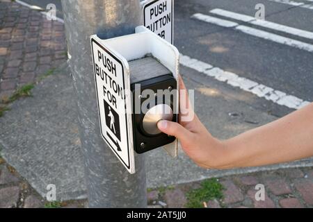 Pedestrian presses the button. A pedestrian light switch with voice guidance and comprehensive operating instructions. Stock Photo