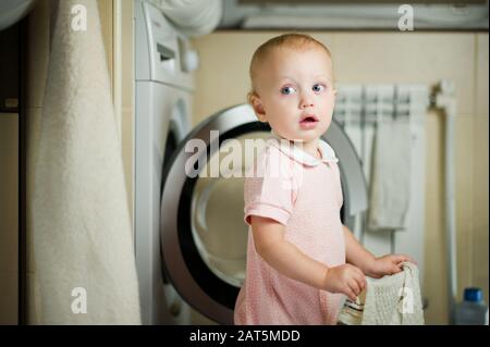 https://l450v.alamy.com/450v/2at5mdd/girl-in-the-bathroom-near-the-washing-machine-with-a-towel-in-her-hand-2at5mdd.jpg