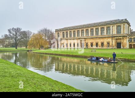 Punting on the river Cam past the wren library at Trinity college, university of Cambridge, England, on a calm and misty winter day. Stock Photo