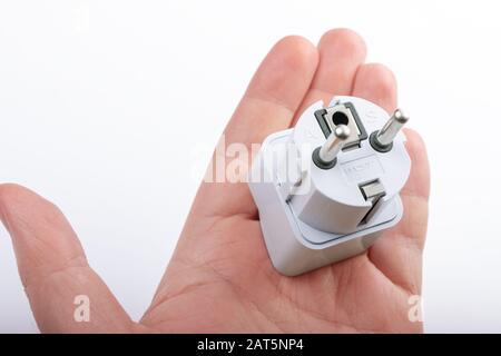 Close up Asia-EU adapter plug on the hand on white background Stock Photo