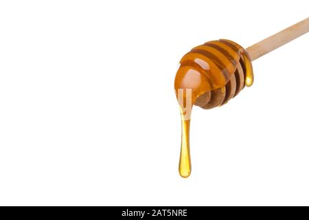 Honey dripping from wooden honey spoon Stock Photo