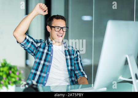 Euphoric happy businessman wear suit celebrate mobile win, excited overjoyed lucky executive winner receive good news in app message use smartphone re Stock Photo