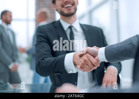 happy business partners shaking hands at the negotiating table. Stock Photo