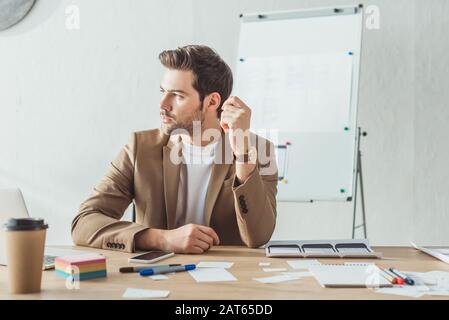 Creative designer looking away at table with mobile application layouts on table Stock Photo