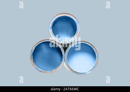 Color of the 2020 year. Three cans filled paint of classic blue color isolated on monument color background. Copy space for your text. Stock Photo