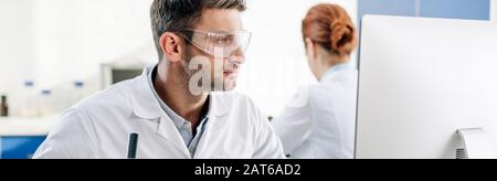 panoramic shot of molecular nutritionist using computer in lab Stock Photo