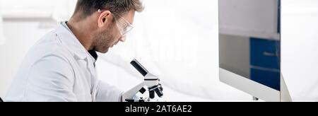 panoramic shot of molecular nutritionist using microscope in lab Stock Photo