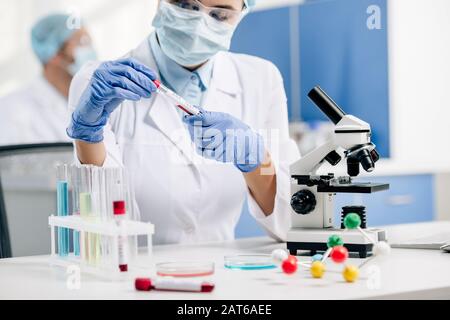 cropped view of genetic consultant in white coat doing dna test in lab Stock Photo