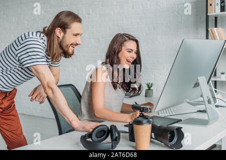 happy art editors smiling near computer monitor Stock Photo