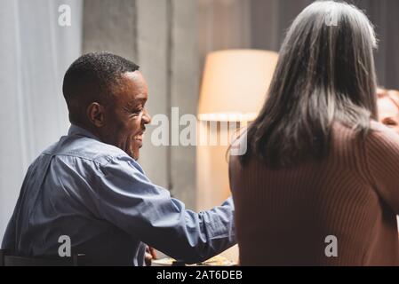 back view of african american man and woman smiling during dinner Stock Photo