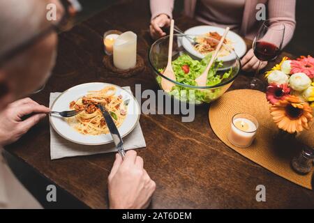 cropped view of man and woman eating pasta during dinner Stock Photo