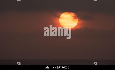 Sunrise over the Pacific Ocean with heavy smog and smoke Stock Photo