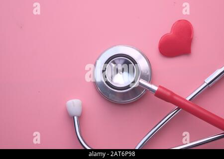 Top view of stethoscope and heart shape on red background Stock Photo