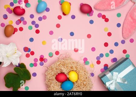 Easter composition eggs bunny confetti box with gift on a pink background. Flat lay, top view, copy space. Stock Photo