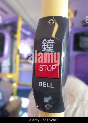 Red stop button on black background on Hong Kong bus Stock Photo