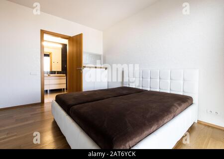 modern bedroom with white bed and bathroom Stock Photo