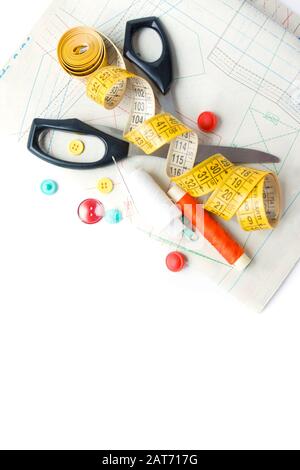 Sewing supplies on white sewing thread, scissors, pattern, centimeter, buttons Stock Photo