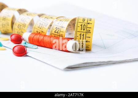 Sewing supplies on white sewing thread, pattern, centimeter, buttons Stock Photo
