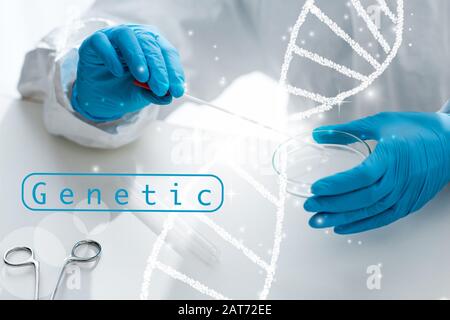 cropped view of scientist doing dna test and sitting near dna illustration Stock Photo