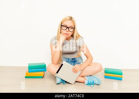 Portrait of minded tired student preparing for session with books and tablet Stock Photo