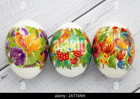 Festive easter gift card. Colorful eggs on wooden white background. Paschal decoration Stock Photo