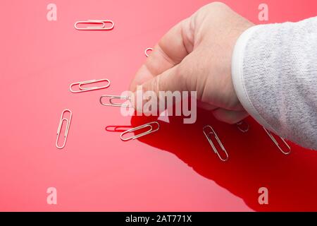 Silver clip ideal for gathering documents, holding papers and having them together; Silver metallic silver wire clip. Simple piece essential in the of Stock Photo