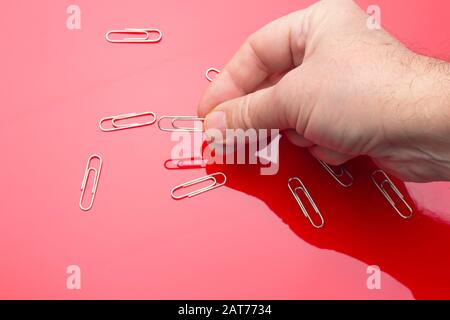 Silver clip ideal for gathering documents, holding papers and having them together; Silver metallic silver wire clip. Simple piece essential in the of Stock Photo