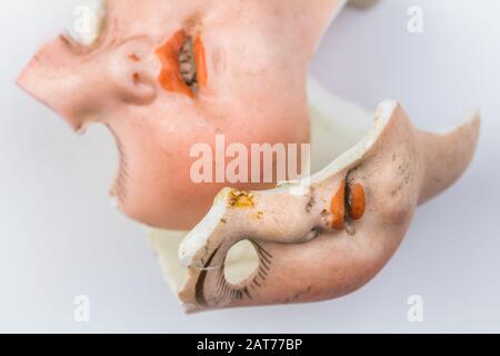 Broken doll faces isolated on white background - conceptual image