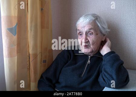 An old woman in his house looking at nothing. Stock Photo