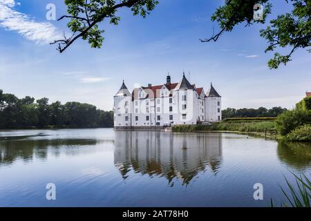 Historic castle with reflection in the lake in Glucksburg, Germany Stock Photo