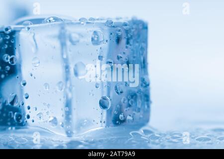 Ice cubes square with drops water clean on blue background Stock Photo