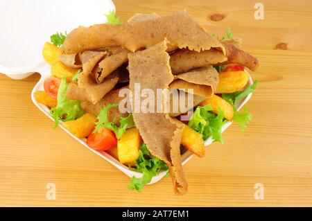 Take away kebab meat and chips with salad in an open fast food box Stock Photo