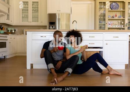 Happy young couple sitting in the kitchen Stock Photo