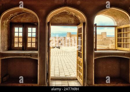 Ruins, towers and walls of the Rayen Citadel viewed through a window, Biggest adobe building in the world, Kerman Province, Iran Stock Photo