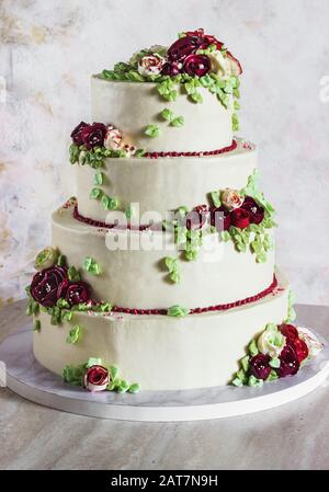 Festive four-level white elegant cake with cream flowers, wedding cake, cream flowers in the Malaysian technique Stock Photo