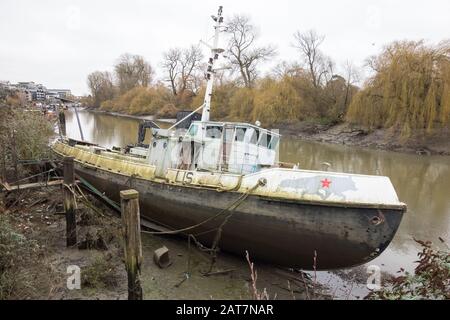 A derelict trawler on the River Thames near the Waterman's Arts Centre, Brentford, London, UK Stock Photo