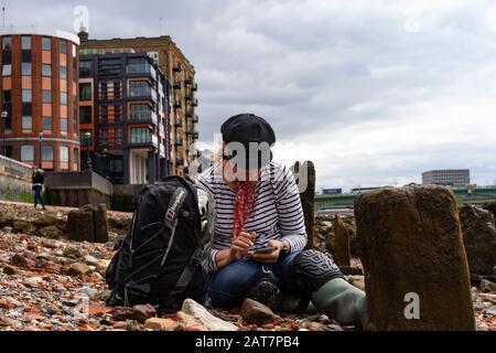 Mud-larker on the river Thames foreshore at low tide, London. Stock Photo