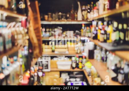 Closeup shot of wine shelf. Bottles lay over straw. Wine cellar. blurred Stock Photo