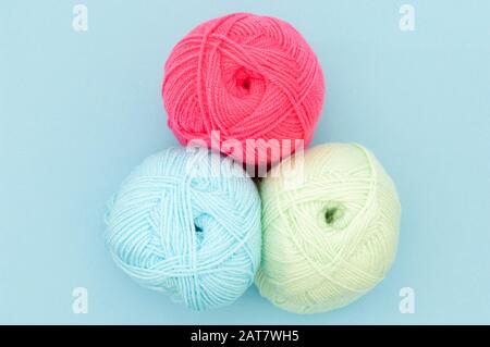 Three Balls of coloured wool on blue background Stock Photo