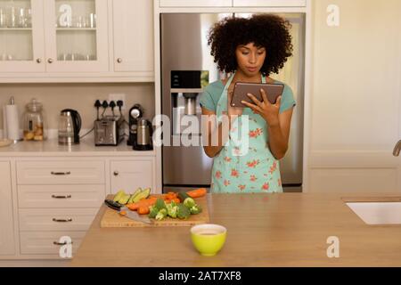 Young woman using tablet computer in the kitchen Stock Photo