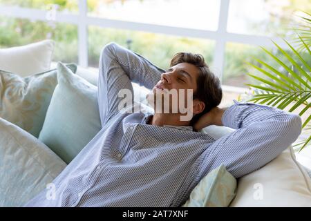 Young man relaxing on sofa at home Stock Photo