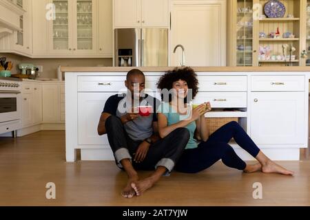 Happy young couple sitting in the kitchen Stock Photo
