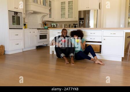 Happy young couple sitting in the kitchen Stock Photo