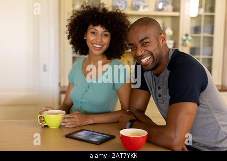 Happy young couple using tablet computer in the kitchen Stock Photo